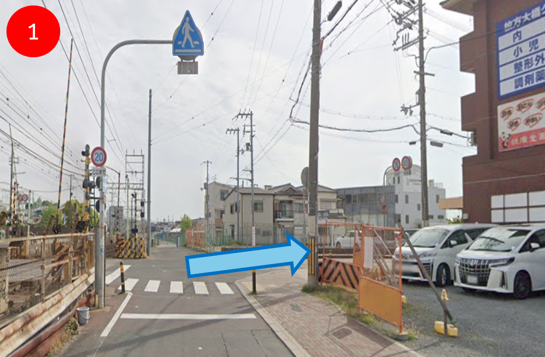 枚方公園駅西口から線路沿いに進み、2つ目の踏切で右に進みます。
